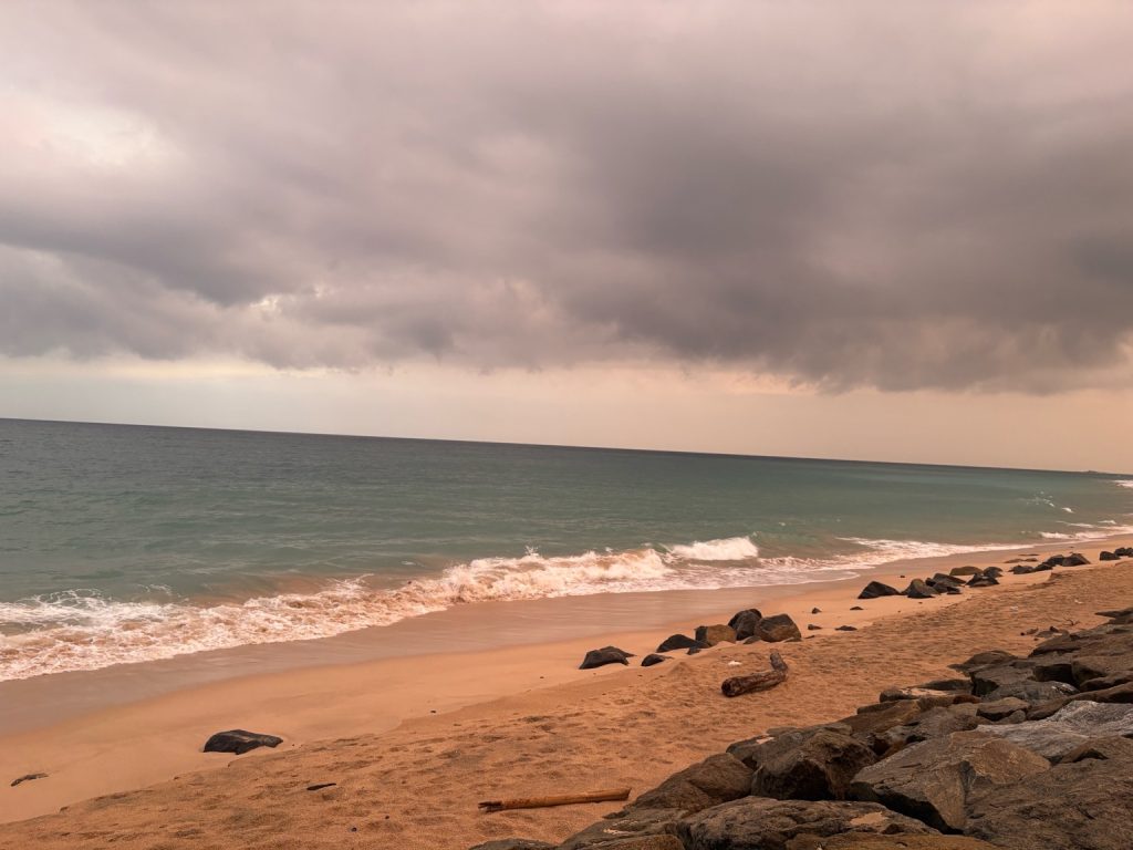 Akurala Beach in Sri Lanka with golden sand, gentle waves, and cloudy skies near Ambalangoda.